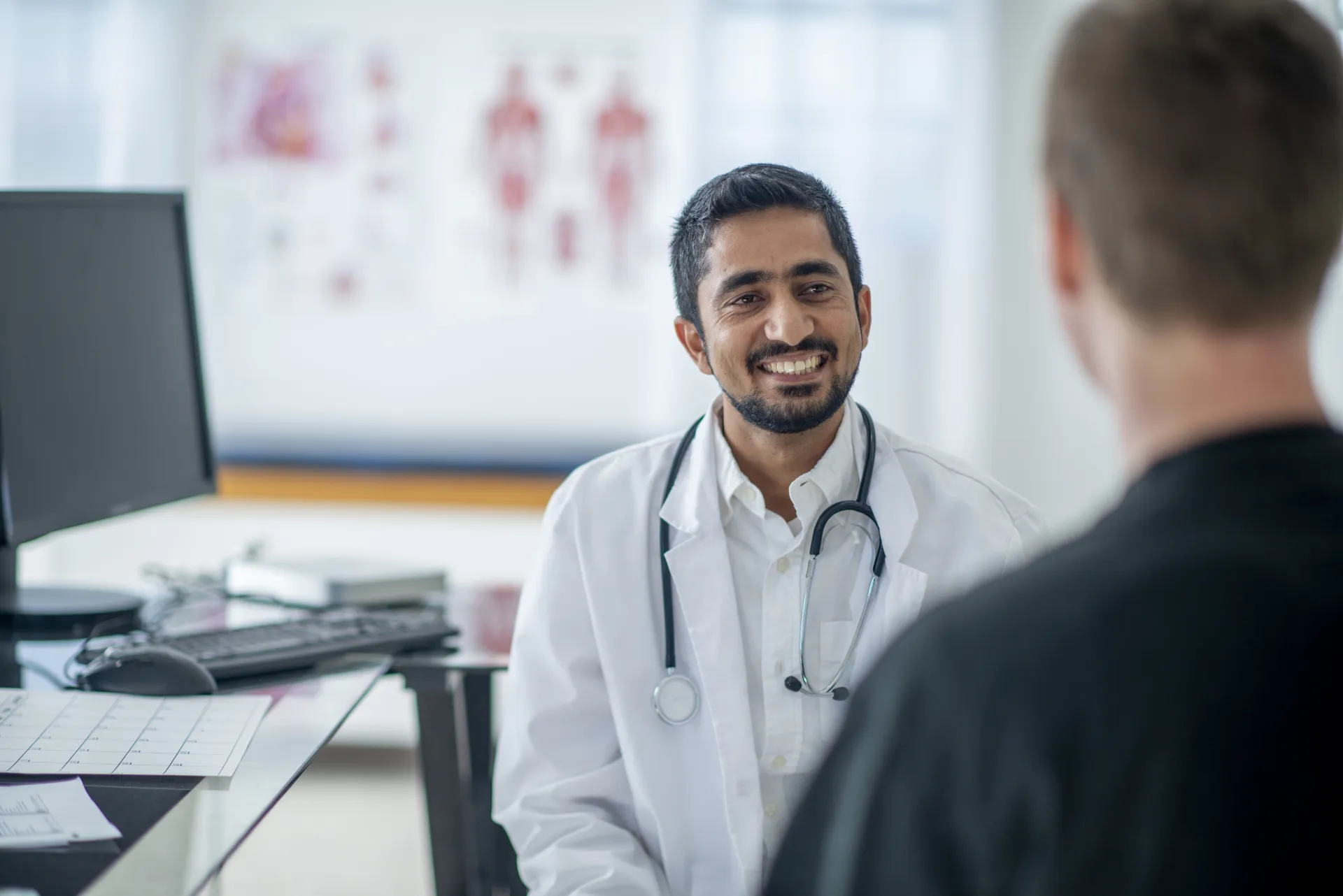 A practice owner meeting with a patient at his desk
