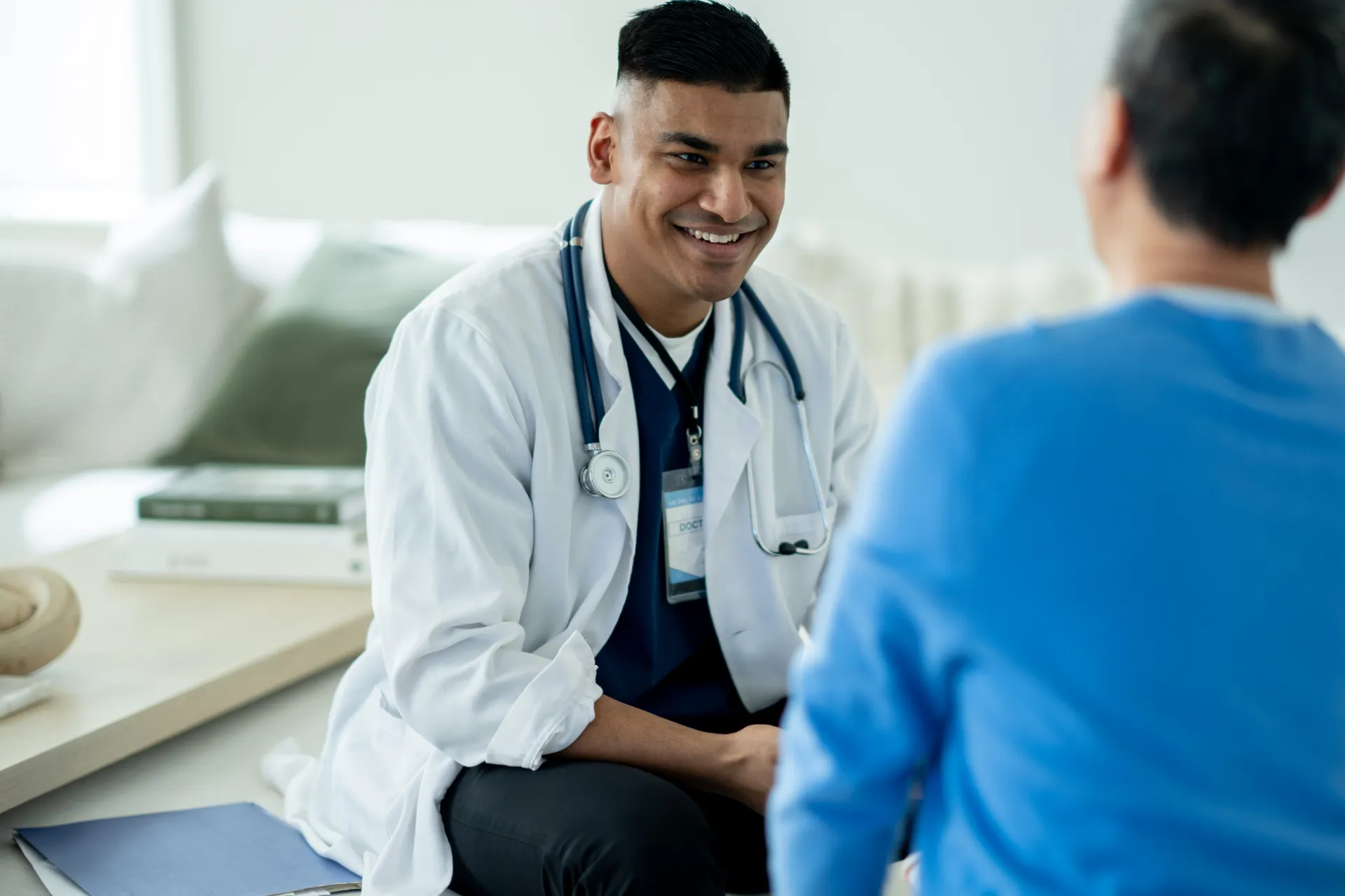 A practice owner talking with a longtime patient in his office